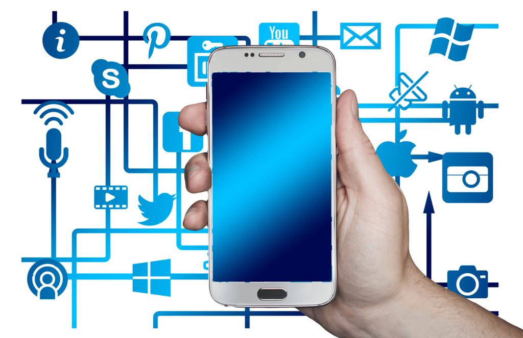 A hand holding a phone demonstrating the art of writing engaging social media captions.